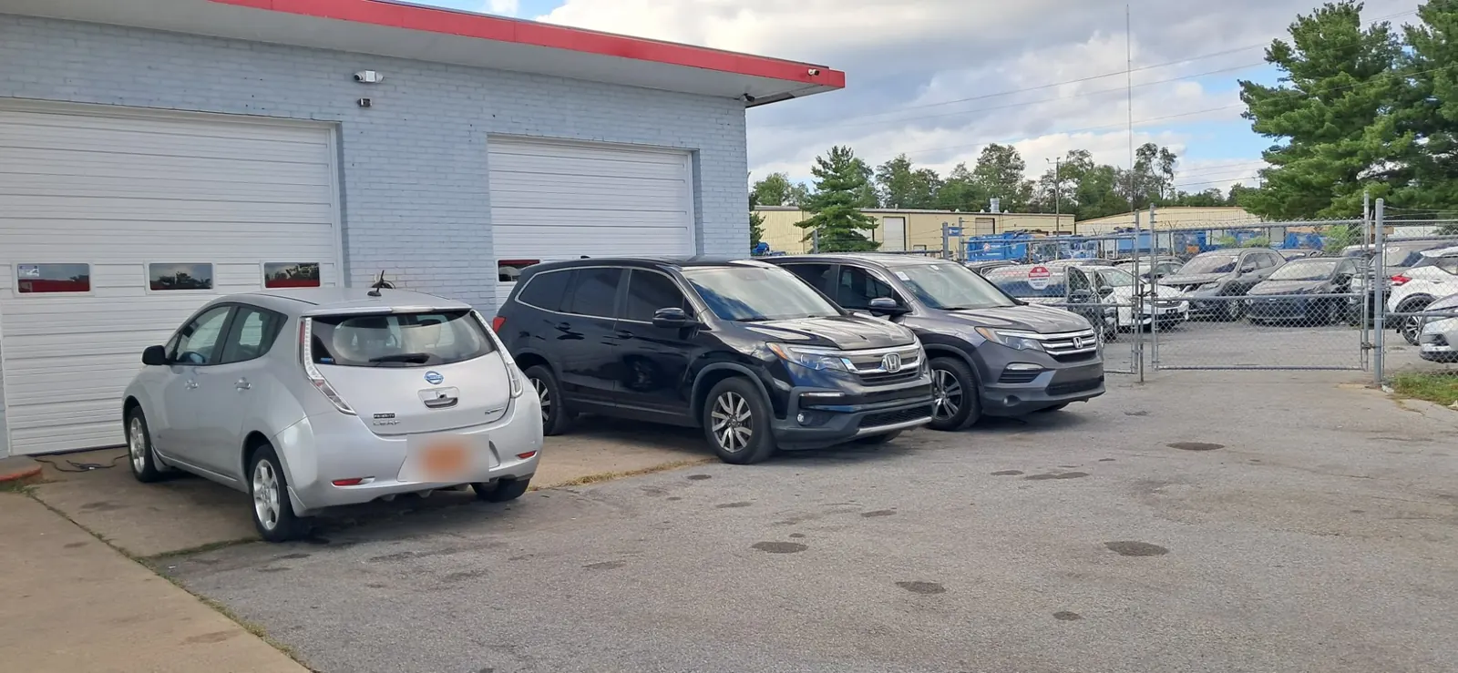 A hatchback and two SUVs parked at the service bays.