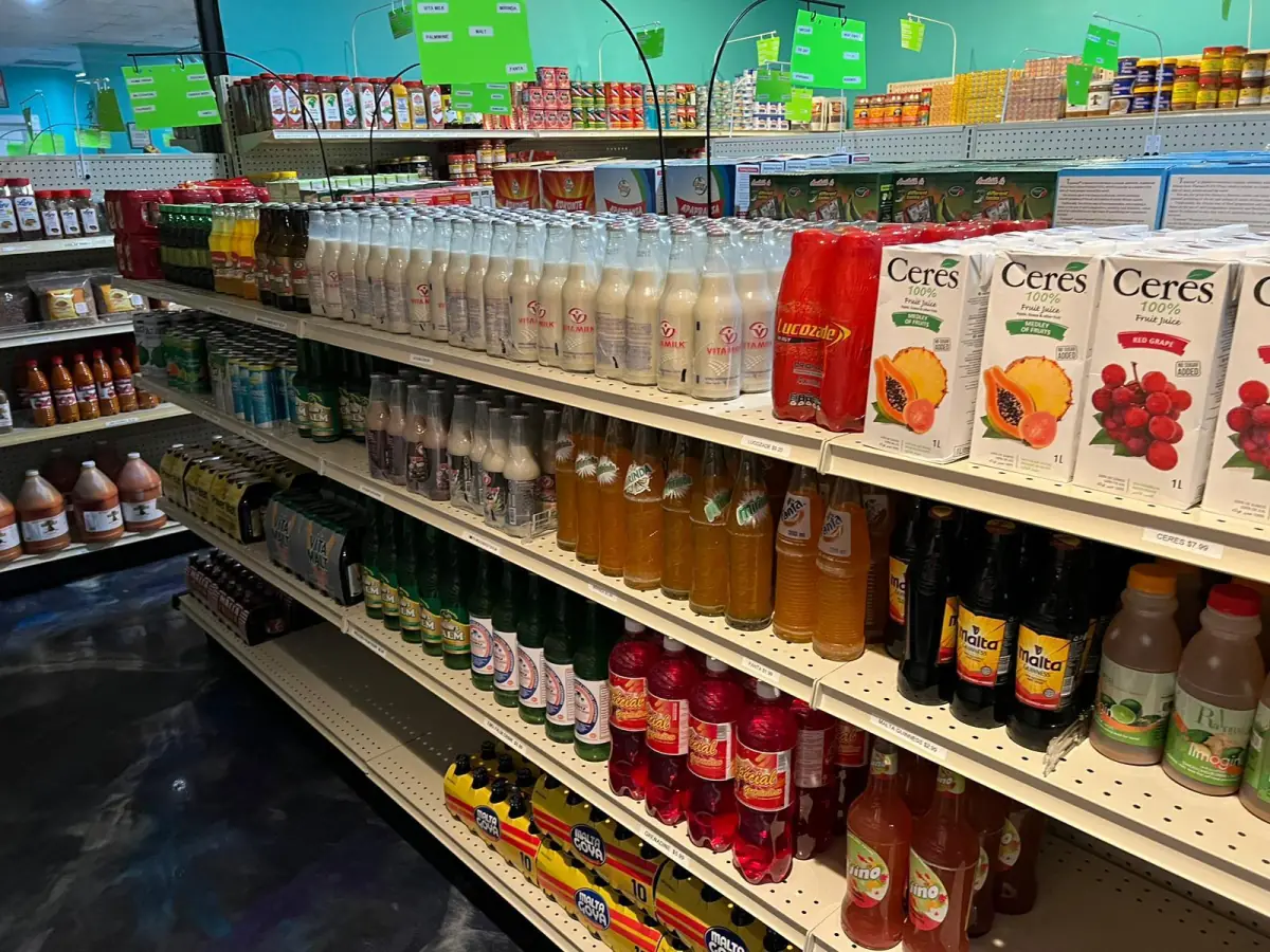 Shelf stocked with juices, malt drinks and other beverages at LIMS Makola International Market.