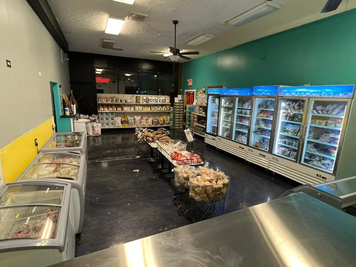 Interior view of freezer cases and grocery displays at LIMS Makola International Market.