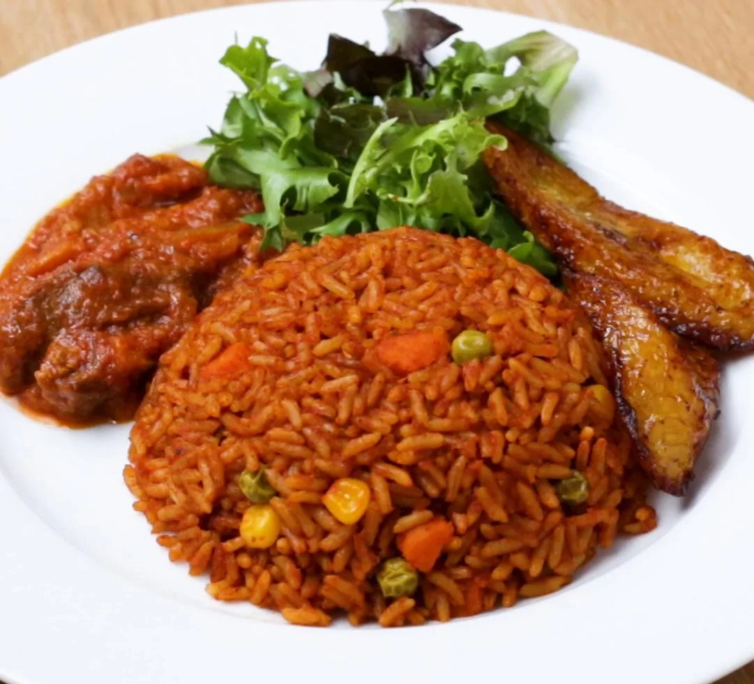 Jollof rice served with stew, plantain and salad.
