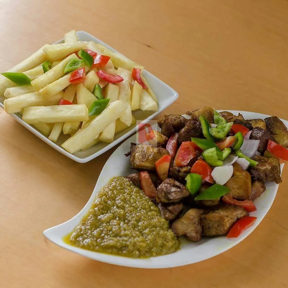 Yam chips served with meat, peppers and green sauce.