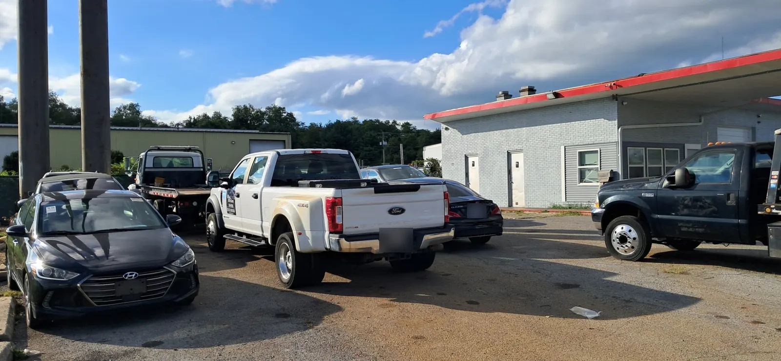 CM Towing flatbed trucks and a work pickup parked at the Hagerstown yard.